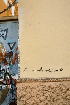 graffiti on the side of a building near a street sign that says la suda est ata ent