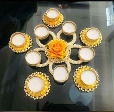 a table topped with lots of white candles and yellow flowers on top of each other