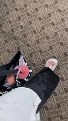 a man laying on the ground with a pink stuffed animal in his lap and shoes