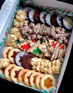 a box filled with lots of different types of cookies and pastries on top of each other