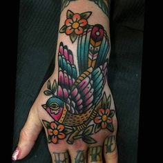 a woman's hand with a bird tattoo on it