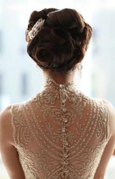 the back of a woman's wedding dress with beaded detailing and pearls on it