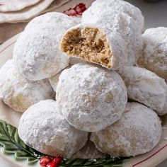 a white plate topped with snowball cookies covered in powdered sugar