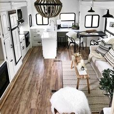 a living room filled with furniture and a chandelier hanging over the top of it