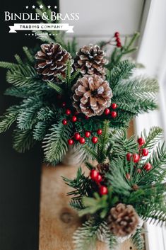 some pine cones and berries are in a vase