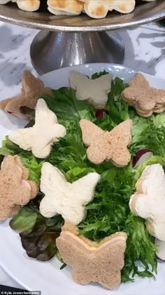 a white plate topped with lettuce and crackers on top of a table