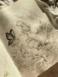 a piece of paper that has some drawings on it with flowers and butterflies in it