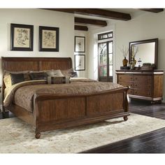 a bed room with a neatly made bed and two dressers on either side of the bed