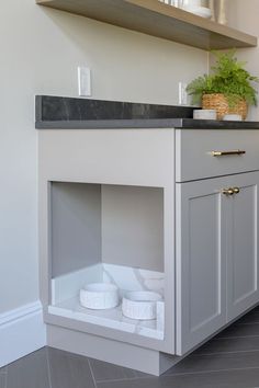 a kitchen with white cabinets and black counter tops, an open drawer under the sink