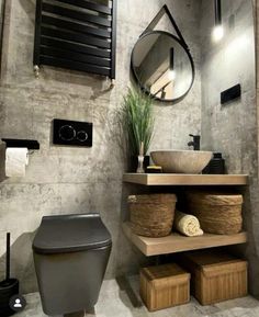 a bathroom with a toilet, sink and mirror on the wall next to trash cans