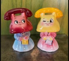 two little plastic toy telephones sitting next to each other on top of a table