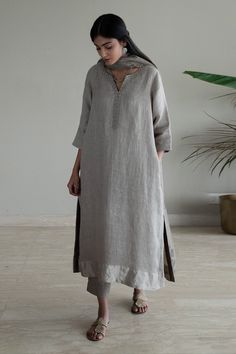 Taupe kurta with woven silver border on sleeve hem, placket and neckline in stripe pattern. Paired with pant.
Components: 2
Pattern: Woven
Type Of Work: Stripe
Neckline: Notched
Sleeve Type: Three quarter
Fabric: Kurta: Handwoven Linen, Pant: Cotton, Lining: Shantoon
Color: Grey
Other Details: 
Side pockets
Attached lining
Note: Dupatta worn by the model is not for sale
Disclaimer: The fabric, color and texture of the final garment might have slight variations from the studio images and we use o Linen Kurti Design, Shorshe Clothing, Linen Suits Women, Grey Kurta, Studio Images, A Line Kurti, New Kurti Designs, Pakistani Fancy Dresses, Linen Pant