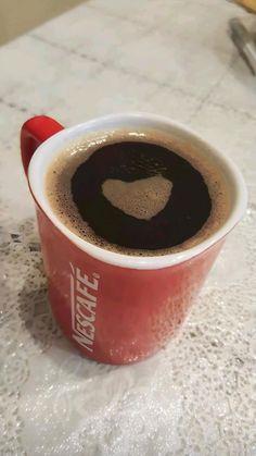 there is a cup of coffee on the table with heart shaped foaming in it