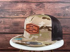 "We proudly launch our hats with genuine leather patch. - PRODUCT DETAILS -----  - Hats are YUPONG 6006 style 5 panel. - The leather patches are crafted from 100% genuine, top-quality leather made in the USA - Adjustable Snapback - One Size Fits All. - 65/35 polyester/cotton - Structured, five-panel, high-profile - Flat bill. - The leather patches on all hats are bonded, not stitched. Our reliable and robust leather bonding technique has been employed for numerous years. - Your logo must be in a black and white JPG format. Ensure that the text and images are in black, while the background should be white. - Explore our diverse range of shapes and fonts! No logo? No worries! We can engrave your custom text using the fonts showcased in our gallery. Additionally, enjoy complimentary custom sh Outdoor Flat Bill Hats With Custom Logo, Outdoor Hats With Custom Logo And Flat Brim, Brown Snapback Hat With Custom Logo For Outdoor, Outdoor Trucker Hat With Leather Patch And Short Brim, Outdoor Short Brim Hats With Logo Patch, Trucker Hat With Leather Patch And Short Brim, Brown Snapback Hat With Short Brim For Outdoor, Brown Leather Patch Baseball Cap With Flat Brim, Outdoor Leather Hat With Custom Logo