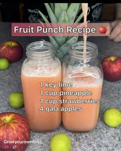 two mason jars filled with liquid next to apples and an apple on the counter top