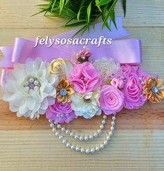 a pink sash with flowers and pearls on it