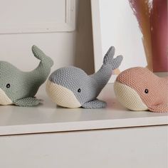 three stuffed animals sitting on top of a white shelf