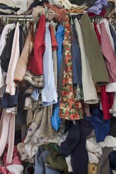 a closet filled with lots of different types of clothes and ties on hangers next to each other