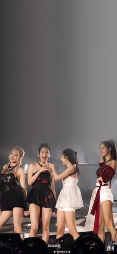 the girls are all dressed up and having fun on stage with their cell phones in their hands