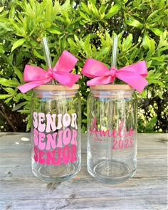 two clear glass jars with pink bows and the words senior, senior and senior on them