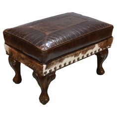 a brown and white ottoman sitting on top of a wooden table