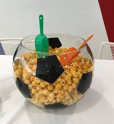 a glass bowl filled with popcorn on top of a table