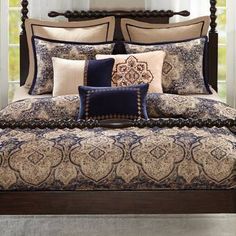 a bed with blue and beige comforters on top of it in a bedroom next to a window