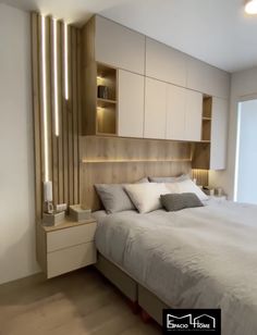 a large bed sitting in a bedroom next to a wall mounted cabinet and night stand