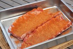 two pieces of meat sitting on top of a metal pan