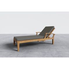 an outdoor chaise lounge chair with grey cushions and wooden frame, sitting on concrete flooring