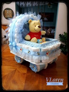 a teddy bear sitting in a baby carriage made out of diapers and cloths