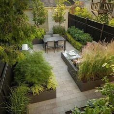 an outdoor dining area with tables and chairs, surrounded by plants in the foreground