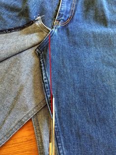 a pair of scissors is cutting through the back pocket of a pair of blue jeans