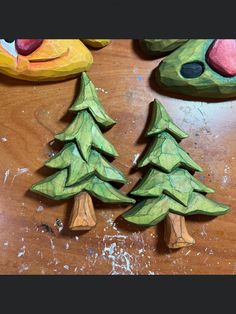 two wooden christmas trees sitting on top of a table