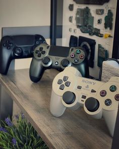 two video game controllers sitting on top of a wooden table