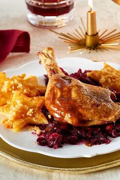 a white plate topped with chicken and cranberry stuffing next to a glass of wine