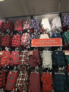 many plaid shirts are on display in a store