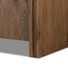 the corner of a wooden cabinet with wood grains on it's sides and an opening at the top