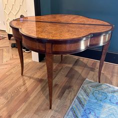 a wooden table sitting on top of a hard wood floor next to a blue wall