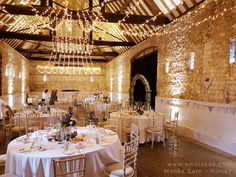 an indoor wedding venue with white tables and chandeliers