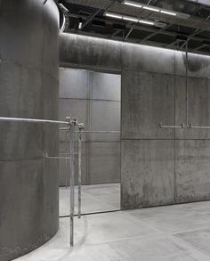 an empty room with several large metal tanks in the center and two bars on each side