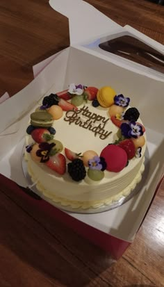 a birthday cake sitting in a box on top of a table