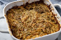 a white casserole dish filled with food on top of a table