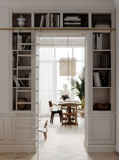 an open bookcase in the middle of a room with a dining table and chairs