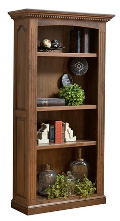 a wooden bookcase with three shelves filled with books and vases on top of it