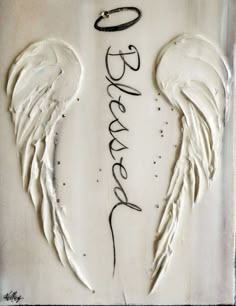 an angel wings with the word heaven written on it