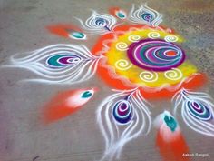 a colorful rangdi design on the ground in front of a parking lot with feathers painted on it