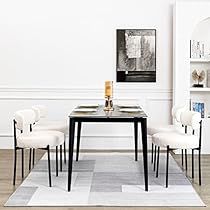 a dining room table with chairs and a rug on the floor in front of it