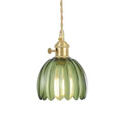 a green glass light hanging from a gold colored ceiling fixture with a cord attached to it