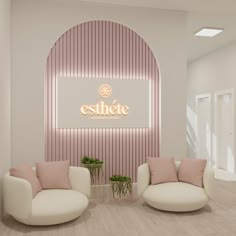 an empty lobby with two white chairs and a pink sign that reads esthete